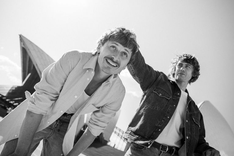 Black and white photo of Australian pop-rock duo Lime Cordiale posing candidly outside the Sydney Opera House.